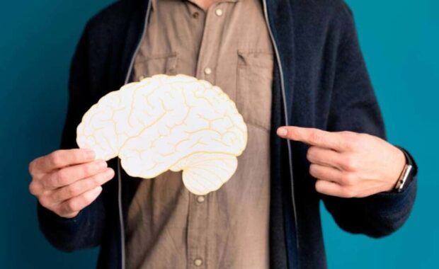 Homem apontando para o cérebro, onde estão localizadas as habilidades cognitivas